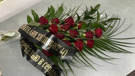 Траурный букет из 16 красных роз и папоротника